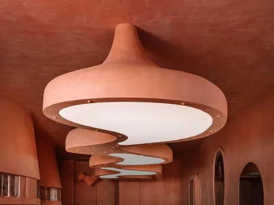 A modern restaurant interior with a sculptural clay light fixture.
