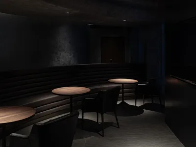 A modern restaurant interior featuring leather seating and wooden tables.