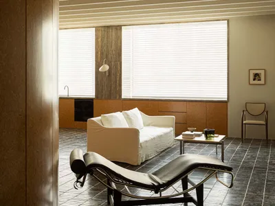 Modern minimalist living room featuring a concrete floor and white furniture.