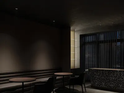 A sleek, dark-themed hotel lounge with modern furniture and dark stone finishes.