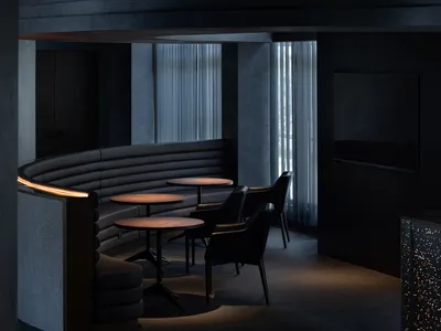 Modern design seating area with round tables and black leather chairs in a restaurant/cafe setting.