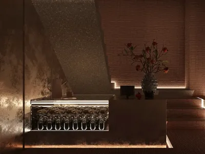 A modern restaurant bar featuring concrete walls and illuminated steps.