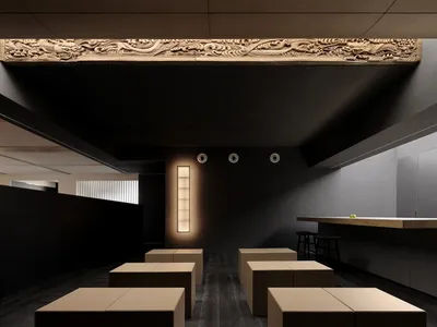 A minimalist restaurant interior featuring dark wood furniture and black light fixtures.