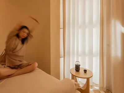 寧靜的臥室場景以中性色調為主，聚焦於柔軟棉質布料營造的舒適放鬆氛圍