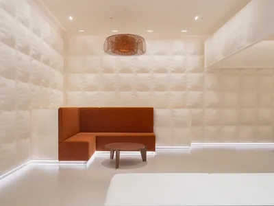 A minimalist hotel suite with white and neutral fabrics in a contemporary design.