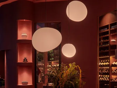 A modern restaurant interior with a terrazzo countertop, pendant lights, and shelves.