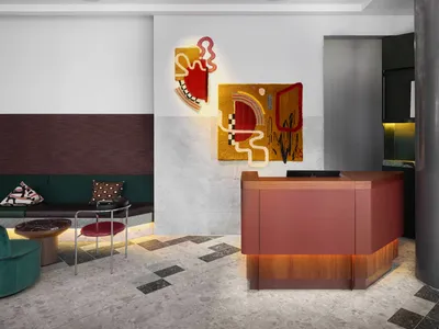 Modern hotel reception area with colorful abstract wall art and mixed materials.