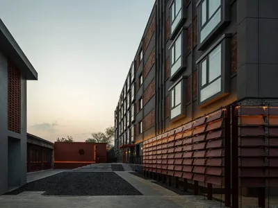 一座現代酒店建築，外牆採用混凝土，搭配玻璃窗。