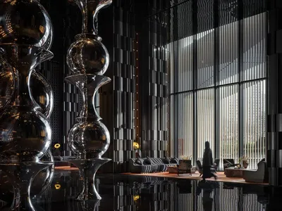 A modern hotel lobby featuring metallic decorative elements and a sleek, contemporary interior design.