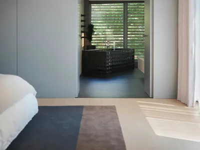 A minimalist bedroom with grey walls, a black bathtub, and large windows with vertical blinds.