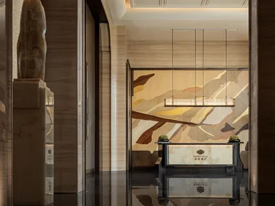 Modern lobby with marble flooring, draped curtains, and elegant furnishings.