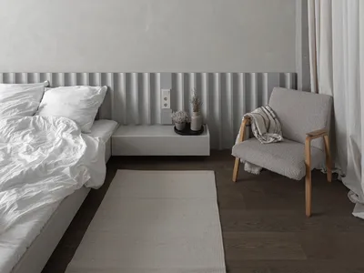 Minimalist bedroom with concrete and wood materials, featuring white bedding and a floating nightstand.