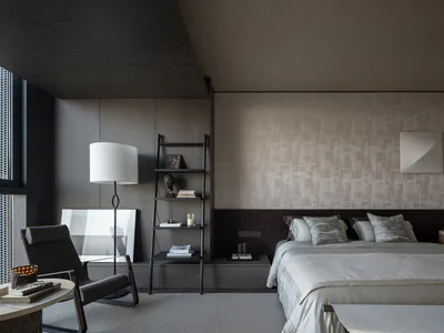 A modern hotel bedroom featuring neutral-toned furniture, minimalist decor, and a large window with views of a cityscape.
