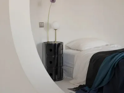 極簡臥室擺放透明花瓶與玻璃床頭櫃。