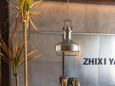 A modern, industrial-style restaurant interior featuring metal tables and chairs, wood accents, and minimalist decor.