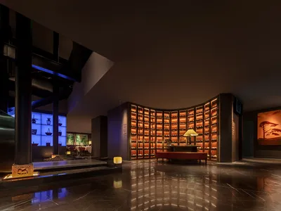 Modern restaurant interior featuring metallic surfaces, wooden elements, and warm lighting.
