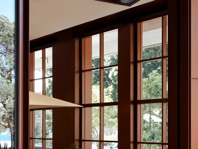 Modern restaurant interior with a long wooden dining table, stone countertops, and contemporary design elements.