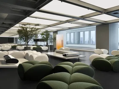 Industrial-style office lounge featuring fabric seating, concrete flooring, and modern metal accents.