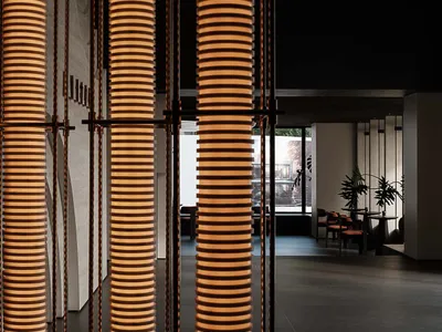 The interior of a modern restaurant featuring glass and metal geometric columns.