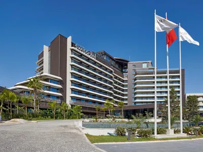 Hotel exterior with modern architectural design featuring concrete, glass, and steel materials.