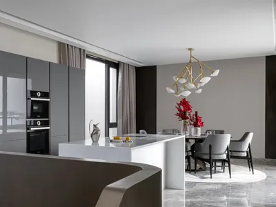 A modern kitchen featuring metallic materials and a marble countertop.