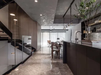 Modern kitchen with marble countertops and floor, featuring minimalist design elements and sleek, black accents.