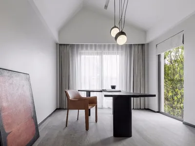 A minimalist study room featuring a black table, brown leather chair, large abstract painting, and white curtains