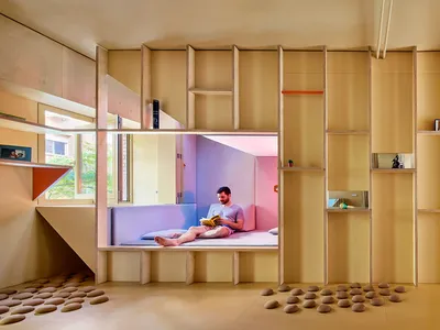 A modern minimalist bedroom with wooden furniture and shelves.