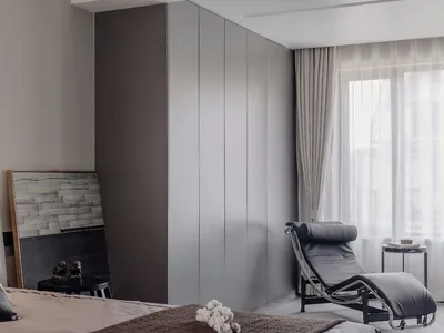 A modern minimalist bedroom featuring contemporary gray paneling and decorative cotton details.