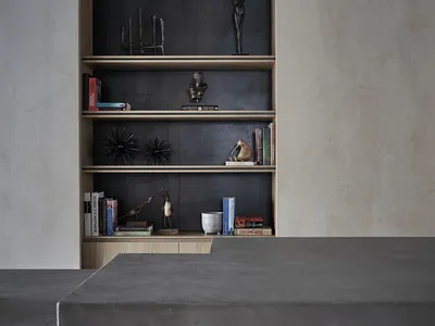 A modern home office with minimalist design, concrete table, wooden shelves, and a combination of concrete and wood materials