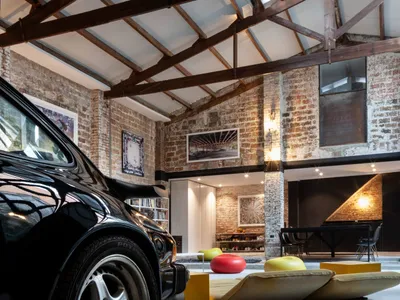 Industrial living room featuring exposed brick walls and concrete floors, with metal and wooden furniture.