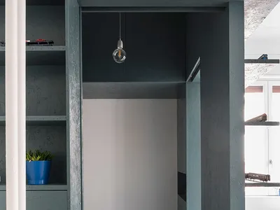 Minimalist bedroom with concrete walls, wooden floor, and bed.