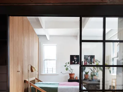 A minimalist bedroom featuring wood and glass elements.