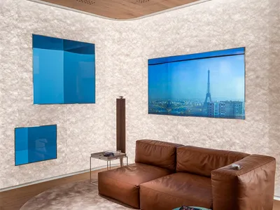 Contemporary living room featuring a brown leather sectional sofa, round rug, and large abstract wall art