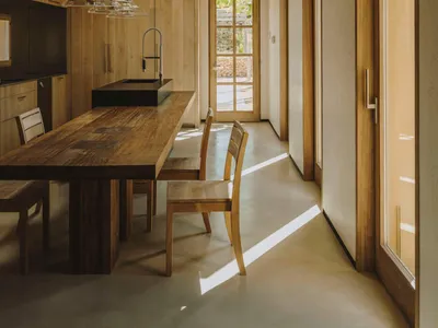 工業風格廚房，設有木質餐桌與餐椅，天窗與大窗引入自然光線