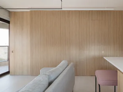 A modern kitchen with wooden panels and a white countertop.