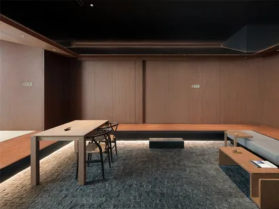 A modern restaurant interior featuring wooden furniture, tables, and benches.