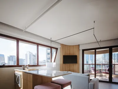 A modern kitchen with wooden cabinets, a white countertop, and a view of the city.