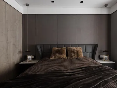 A modern minimalist bedroom featuring a bed with leather headboard and brown fabric bedding, alongside plush pillows and a co