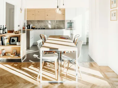 Modern open-plan living, dining, and kitchen area with wooden and metal accents