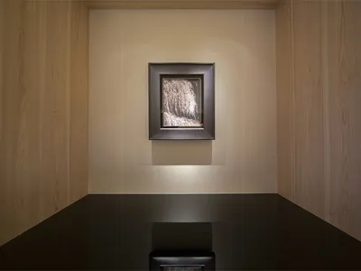 Modern interior design featuring a photograph of a minimalist space with wooden walls and a black table.