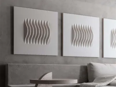 Modern minimalist living room featuring a grey upholstered sofa, a textured concrete side table, and three abstract white scu