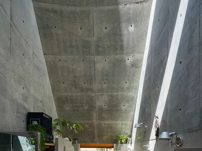 現代簡約廚房，搭配混凝土天花板與地板，設有水槽、爐灶及洗衣機