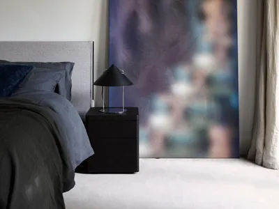 Modern bedroom featuring abstract fabric texture art, minimalist design, and contemporary interior elements.