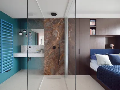 A modern bedroom suite featuring blue-green marble walls and glass elements.