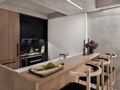 A modern kitchen with wooden cabinets and a wooden counter, featuring a minimalist design.