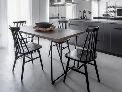 Contemporary kitchen with white cabinets, metallic surfaces, and concrete flooring.