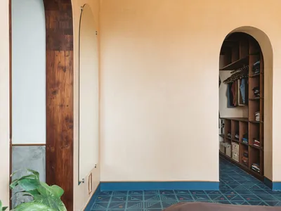 An image of a minimalist bedroom with concrete walls and patterned flooring.