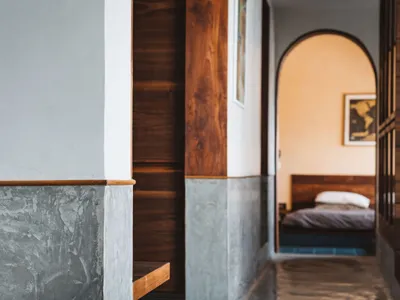 A minimalist bedroom with concrete, wood, and metal elements.