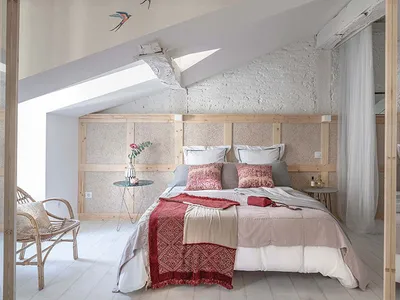 A minimalist bedroom with a wooden bed frame, textured walls, and simple decor.